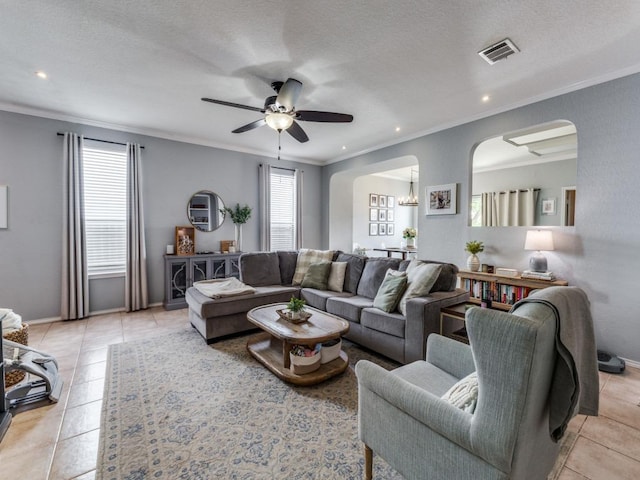 13320 Gilwell Dr, Del Valle, TX 78617 - living area with arched walkways, ornamental molding, ceiling fan, light tile patterned floors, and recessed lighting
