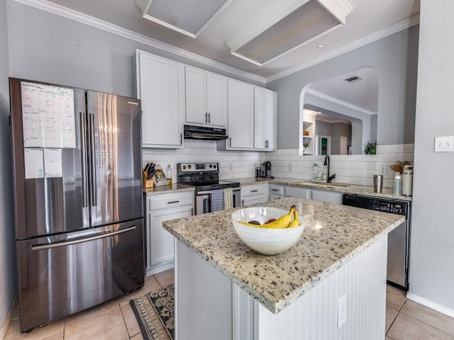 13320 Gilwell Dr, Del Valle, TX 78617 - kitchen featuring stainless steel appliances, under cabinet range hood, light tile patterned floors, backsplash, and a center island