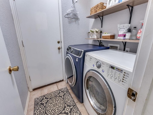 13320 Gilwell Dr, Del Valle, TX 78617 - laundry area featuring washer and dryer, light tile patterned floors, and a textured wall