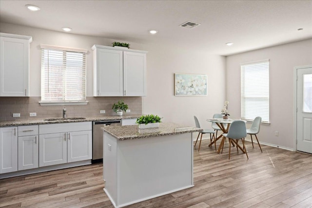 212 Gunther Way, Taylor, TX 76574 - kitchen with dishwasher, tasteful backsplash, light wood-style flooring, white cabinetry, and recessed lighting