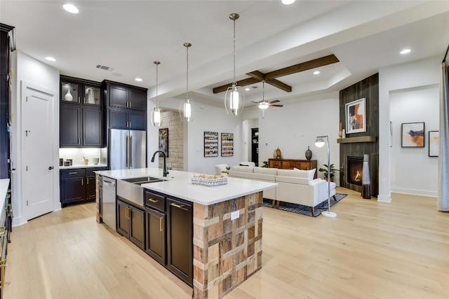 19617 Serenity Ln, Lago Vista, TX 78645 - kitchen with appliances with stainless steel finishes, coffered ceiling, a fireplace, light wood finished floors, and light countertops