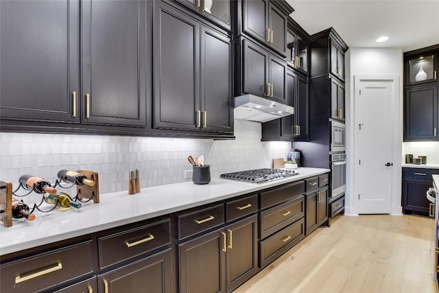 19617 Serenity Ln, Lago Vista, TX 78645 - kitchen with stainless steel appliances, tasteful backsplash, glass insert cabinets, under cabinet range hood, and light countertops