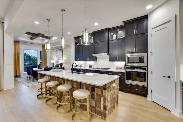 19617 Serenity Ln, Lago Vista, TX 78645 - kitchen featuring appliances with stainless steel finishes, light wood-type flooring, backsplash, a kitchen bar, and recessed lighting