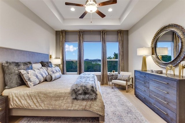 19617 Serenity Ln, Lago Vista, TX 78645 - bedroom with a raised ceiling, light wood-style flooring, a ceiling fan, and recessed lighting
