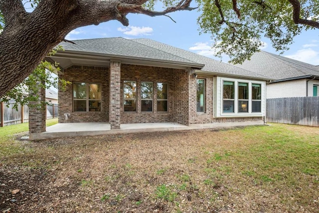 1921 Sauterne Dr, Leander, TX 78641 - rear view of house featuring brick siding, a fenced backyard, a patio area, and a shingled roof