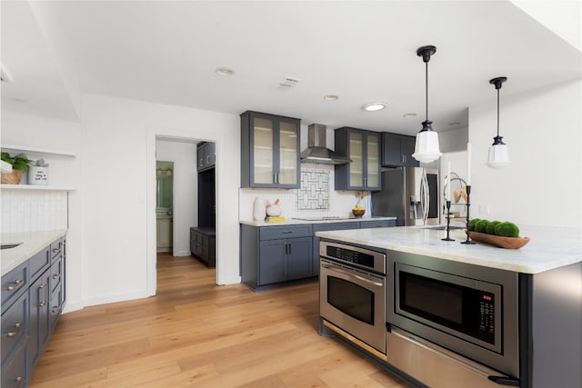 9309 Cedar Forest Dr, Austin, TX 78750 - kitchen featuring stainless steel appliances, wall chimney exhaust hood, tasteful backsplash, light wood finished floors, and recessed lighting