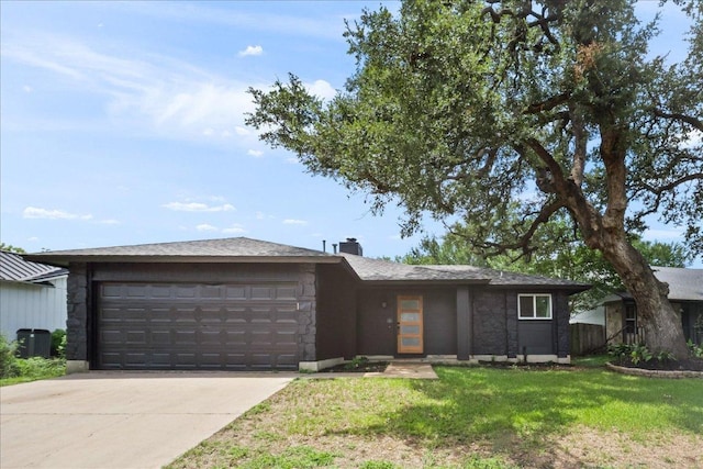 3803 Alexandria Dr, Austin, TX 78749 - view of front of home featuring an attached garage, concrete driveway, stone siding, a front lawn, and a chimney