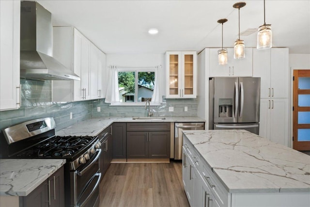 3803 Alexandria Dr, Austin, TX 78749 - kitchen with stainless steel appliances, wall chimney range hood, wood finished floors, glass insert cabinets, and backsplash