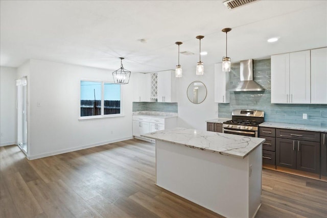 3803 Alexandria Dr, Austin, TX 78749 - kitchen with wall chimney range hood, stainless steel range with gas cooktop, tasteful backsplash, a chandelier, and pendant lighting