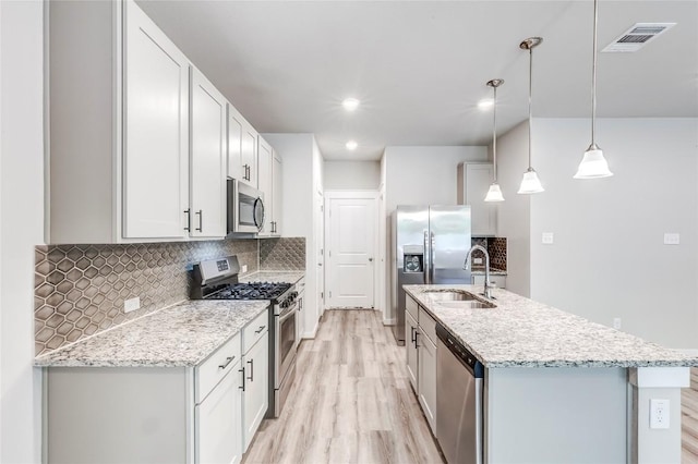 17200C Crane Fly Dr Unit C, Pflugerville, TX 78660 - kitchen featuring stainless steel appliances, light wood-style flooring, tasteful backsplash, a kitchen island with sink, and recessed lighting