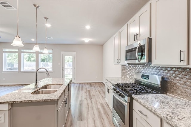 17200C Crane Fly Dr Unit C, Pflugerville, TX 78660 - kitchen featuring appliances with stainless steel finishes, light wood-type flooring, backsplash, light stone countertops, and recessed lighting