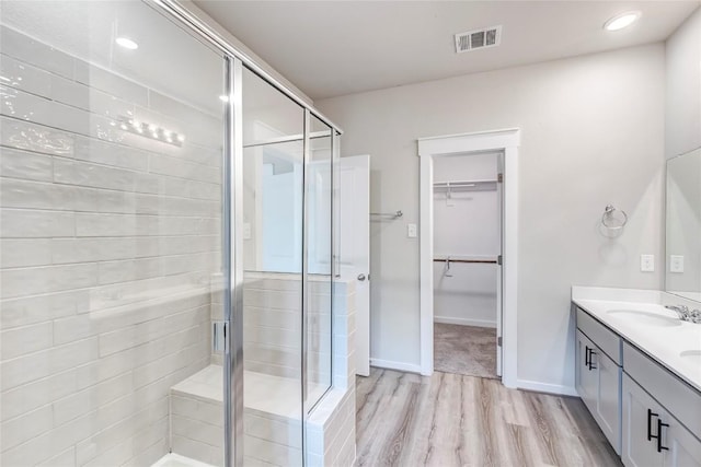 17200C Crane Fly Dr Unit C, Pflugerville, TX 78660 - full bathroom featuring double vanity, a stall shower, a spacious closet, wood finished floors, and recessed lighting