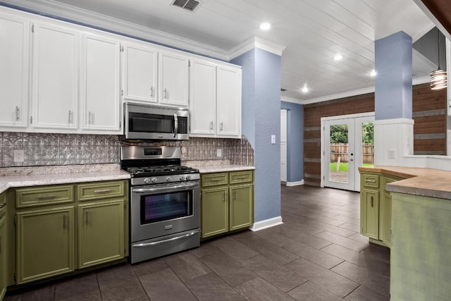607 County Cork Ln, Leander, TX 78641 - kitchen with appliances with stainless steel finishes, green cabinets, crown molding, backsplash, and white cabinets