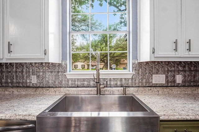 607 County Cork Ln, Leander, TX 78641 - kitchen with white cabinetry, tasteful backsplash, light stone counters, and plenty of natural light