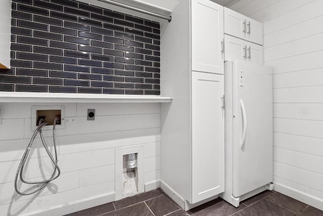 607 County Cork Ln, Leander, TX 78641 - washroom with cabinet space, dark tile patterned flooring, electric dryer hookup, wood walls, and hookup for a washing machine
