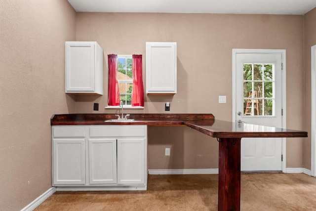 607 County Cork Ln, Leander, TX 78641 - kitchen with dark countertops, light carpet, and white cabinets
