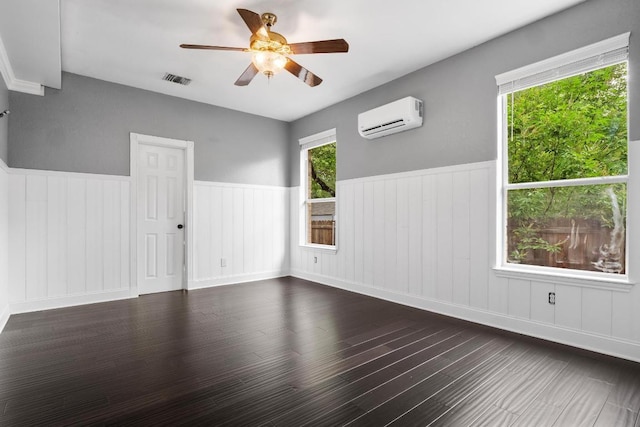 607 County Cork Ln, Leander, TX 78641 - empty room with a wall unit AC, ceiling fan, a wainscoted wall, and dark wood finished floors