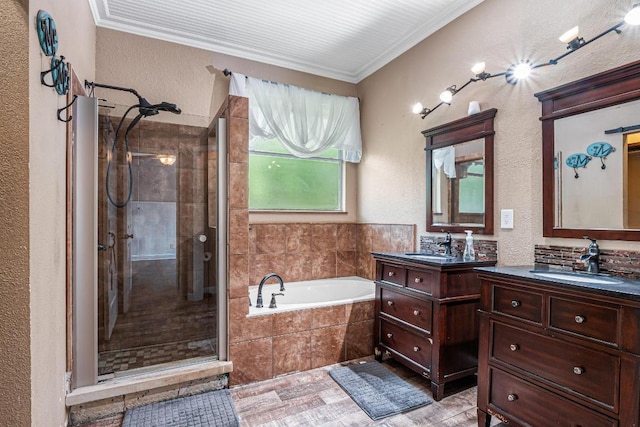 607 County Cork Ln, Leander, TX 78641 - full bathroom with a stall shower, two vanities, a bath, ornamental molding, and a textured wall