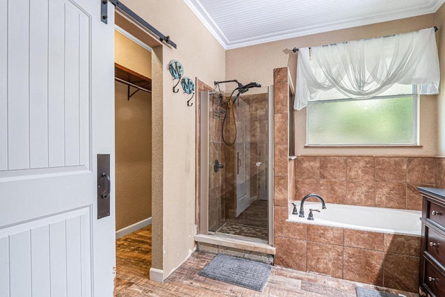 607 County Cork Ln, Leander, TX 78641 - full bathroom with a stall shower, a bath, ornamental molding, a spacious closet, and wood finished floors