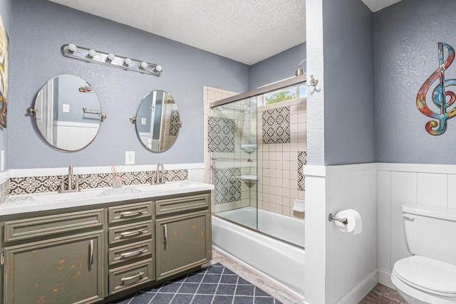 607 County Cork Ln, Leander, TX 78641 - bathroom with a textured ceiling, double vanity, combined bath / shower with glass door, and a textured wall