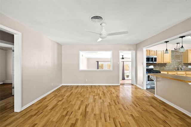 2301 Westworth Cir, Austin, TX 78704 - unfurnished living room featuring a ceiling fan and light wood-style floors