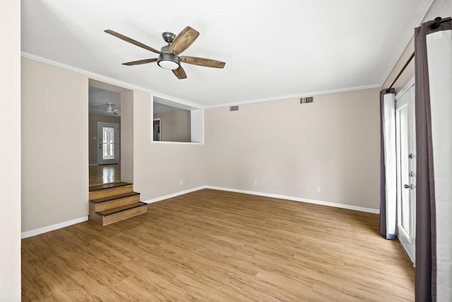 2301 Westworth Cir, Austin, TX 78704 - spare room featuring crown molding, a ceiling fan, light wood-style floors, and stairway
