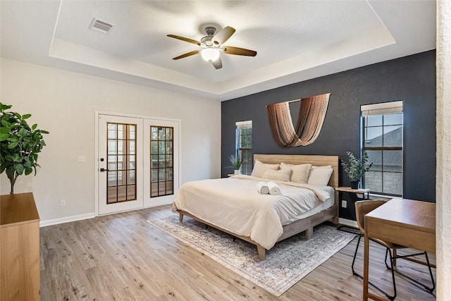 220 Meadow Oaks Dr, Dripping Springs, TX 78620 - bedroom with a raised ceiling, wood finished floors, and ceiling fan