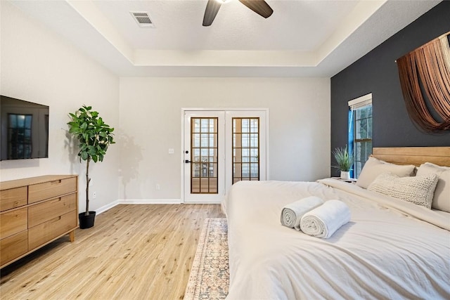 220 Meadow Oaks Dr, Dripping Springs, TX 78620 - bedroom with a tray ceiling, light wood-style flooring, and ceiling fan