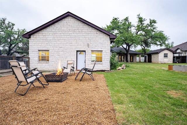 220 Meadow Oaks Dr, Dripping Springs, TX 78620 - back of house featuring stone siding, a lawn, and a fire pit
