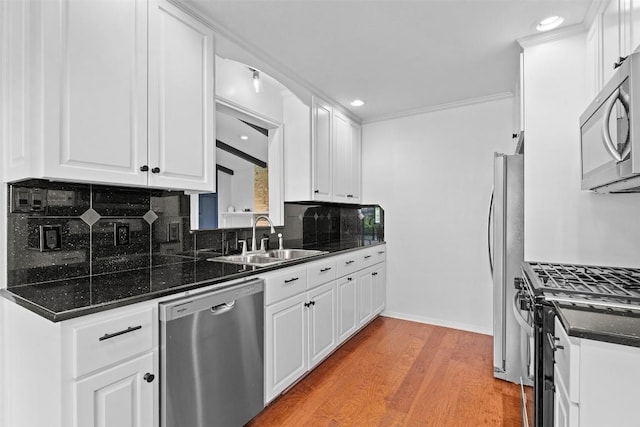 2601 Ashdale Dr, Austin, TX 78757 - kitchen with stainless steel appliances, decorative backsplash, white cabinetry, light wood-style floors, and recessed lighting