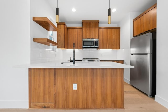 7706 Watson St Unit 2, Austin, TX 78757 - kitchen featuring stainless steel appliances, open shelves, brown cabinets, a peninsula, and light countertops