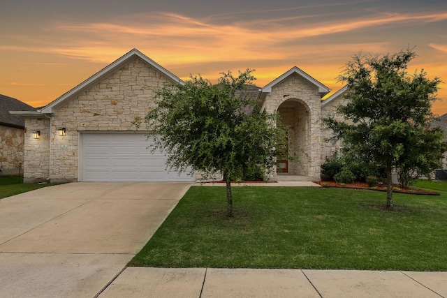 16713 Elsinore Ln, Pflugerville, TX 78660 - view of front of home with stone siding, a front yard, an attached garage, and driveway