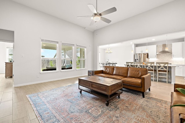16713 Elsinore Ln, Pflugerville, TX 78660 - living area featuring ceiling fan, light wood-style floors, a towering ceiling, and a chandelier