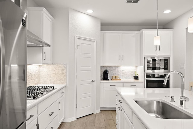 16713 Elsinore Ln, Pflugerville, TX 78660 - kitchen with stainless steel appliances, white cabinets, recessed lighting, backsplash, and light countertops