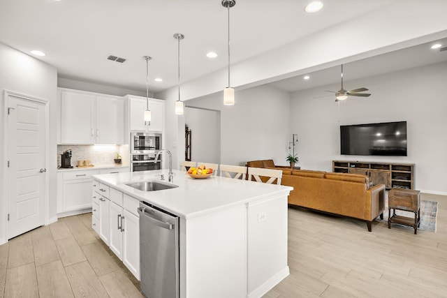 16713 Elsinore Ln, Pflugerville, TX 78660 - kitchen featuring stainless steel appliances, light wood-type flooring, recessed lighting, a ceiling fan, and a kitchen island with sink