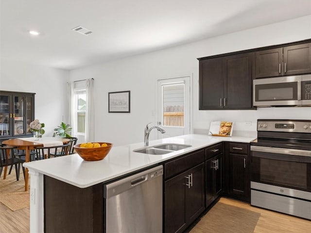 308 Sunfish Ln, Bastrop, TX 78602 - kitchen featuring appliances with stainless steel finishes, light countertops, light wood-style floors, and a peninsula