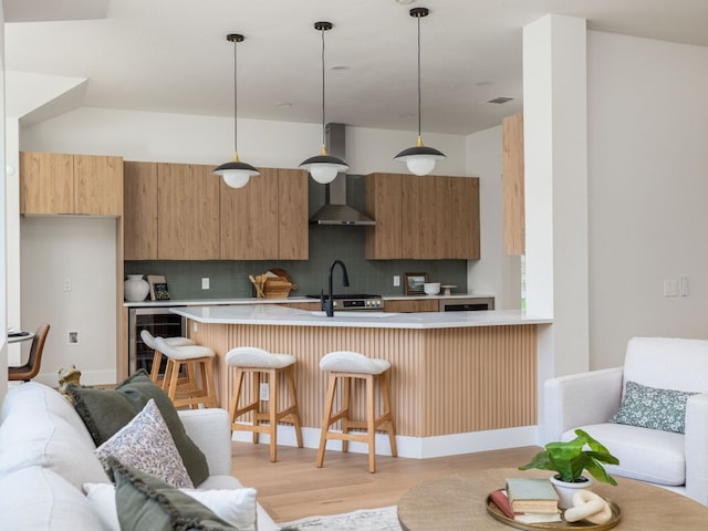 6000 Roxbury Ln, Austin, TX 78739 - kitchen with wall chimney exhaust hood, wine cooler, decorative backsplash, light countertops, and a kitchen breakfast bar