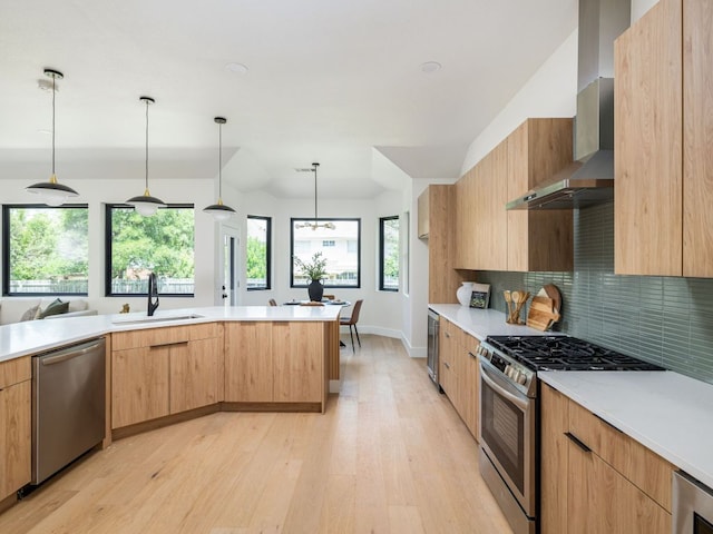 6000 Roxbury Ln, Austin, TX 78739 - kitchen featuring appliances with stainless steel finishes, wall chimney range hood, light wood finished floors, light countertops, and decorative backsplash