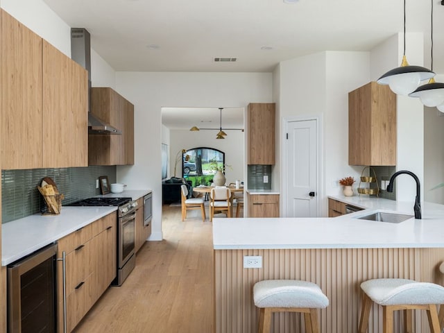 6000 Roxbury Ln, Austin, TX 78739 - kitchen featuring wine cooler, appliances with stainless steel finishes, wall chimney exhaust hood, decorative backsplash, and a peninsula