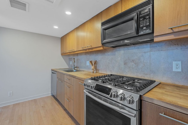 1212 Guadalupe St Unit 805, Austin, TX 78701 - kitchen featuring appliances with stainless steel finishes, wooden counters, decorative backsplash, light wood-type flooring, and recessed lighting