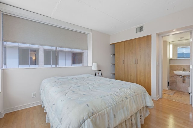 1212 Guadalupe St Unit 805, Austin, TX 78701 - bedroom featuring light wood finished floors, a closet, and ensuite bath