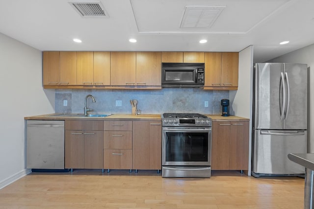 1212 Guadalupe St Unit 805, Austin, TX 78701 - kitchen with appliances with stainless steel finishes, light wood finished floors, backsplash, light countertops, and recessed lighting
