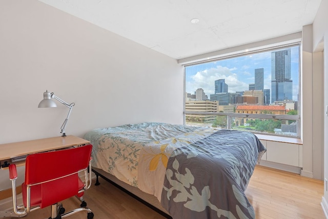 1212 Guadalupe St Unit 805, Austin, TX 78701 - bedroom with a view of skyline and wood finished floors