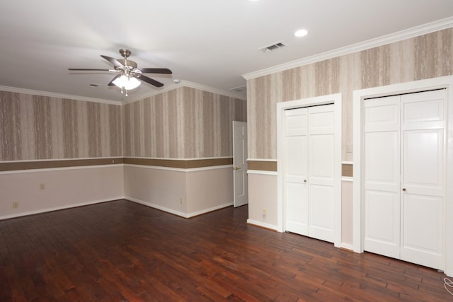 1404 Pearl Cv, Round Rock, TX 78681 - unfurnished bedroom with multiple closets, dark wood finished floors, wallpapered walls, crown molding, and ceiling fan