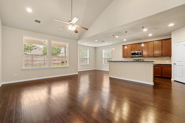 605 Joppa Rd, Leander, TX 78641 - kitchen with stainless steel microwave, open floor plan, a ceiling fan, vaulted ceiling, and dark wood-style floors