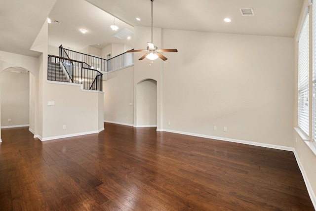 605 Joppa Rd, Leander, TX 78641 - unfurnished living room featuring arched walkways, ceiling fan, dark wood-style floors, stairs, and recessed lighting