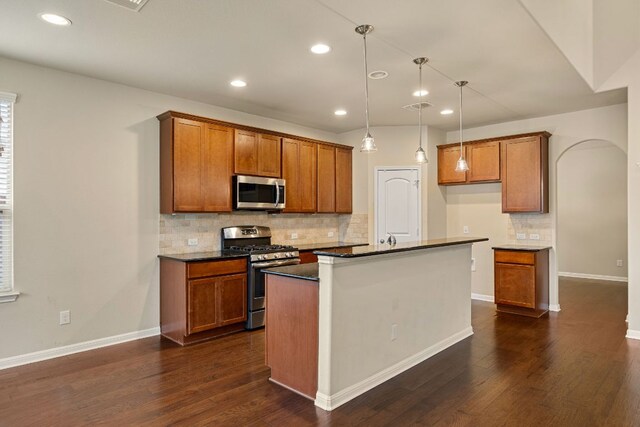605 Joppa Rd, Leander, TX 78641 - kitchen with appliances with stainless steel finishes, brown cabinetry, dark countertops, backsplash, and dark wood-style flooring