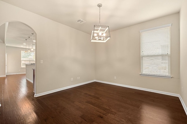 605 Joppa Rd, Leander, TX 78641 - spare room featuring arched walkways, dark wood-style flooring, and a chandelier