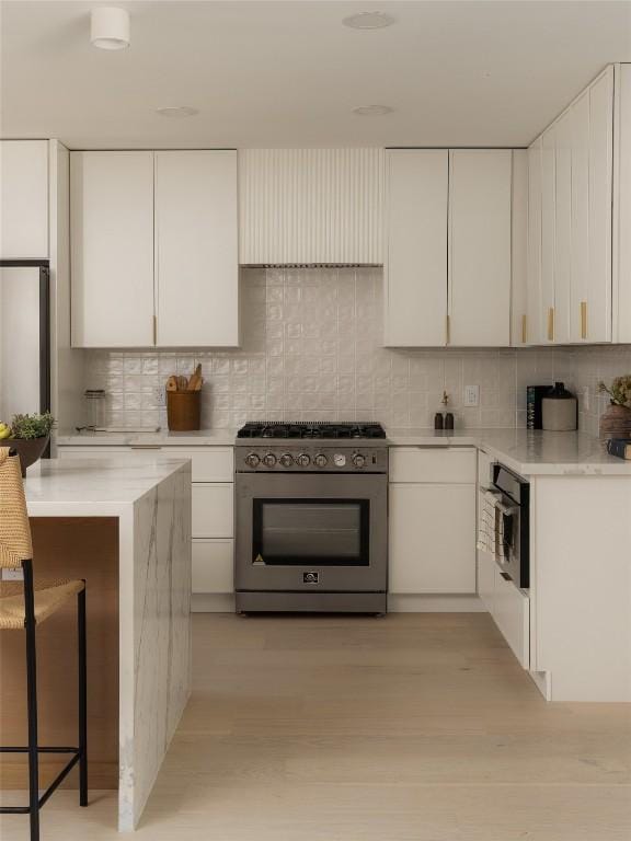 1206 Cloverleaf Dr, Austin, TX 78723 - kitchen with stainless steel stove, decorative backsplash, and white cabinetry