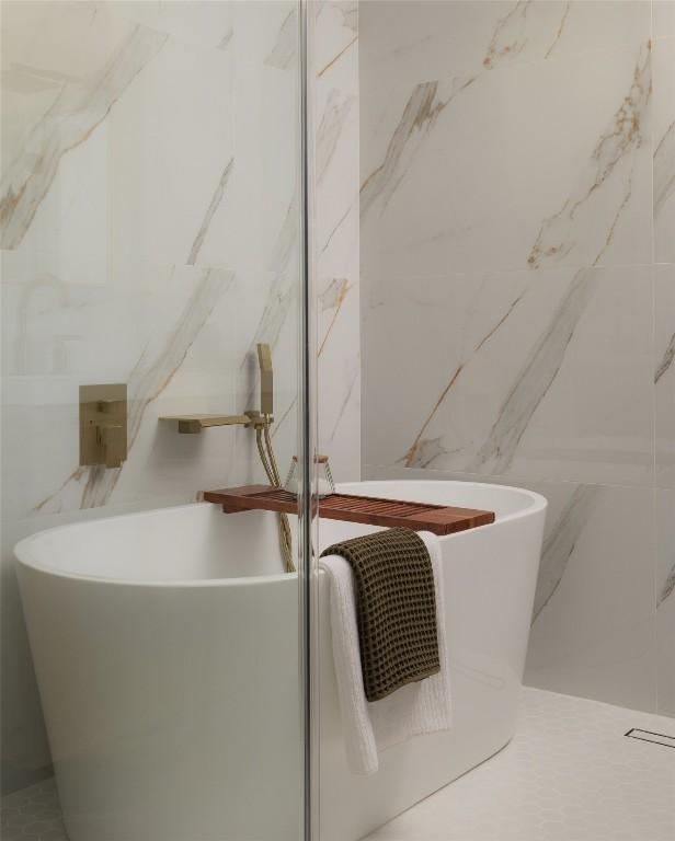1206 Cloverleaf Dr, Austin, TX 78723 - bathroom view of a freestanding bath, a marble finish shower, and tile walls